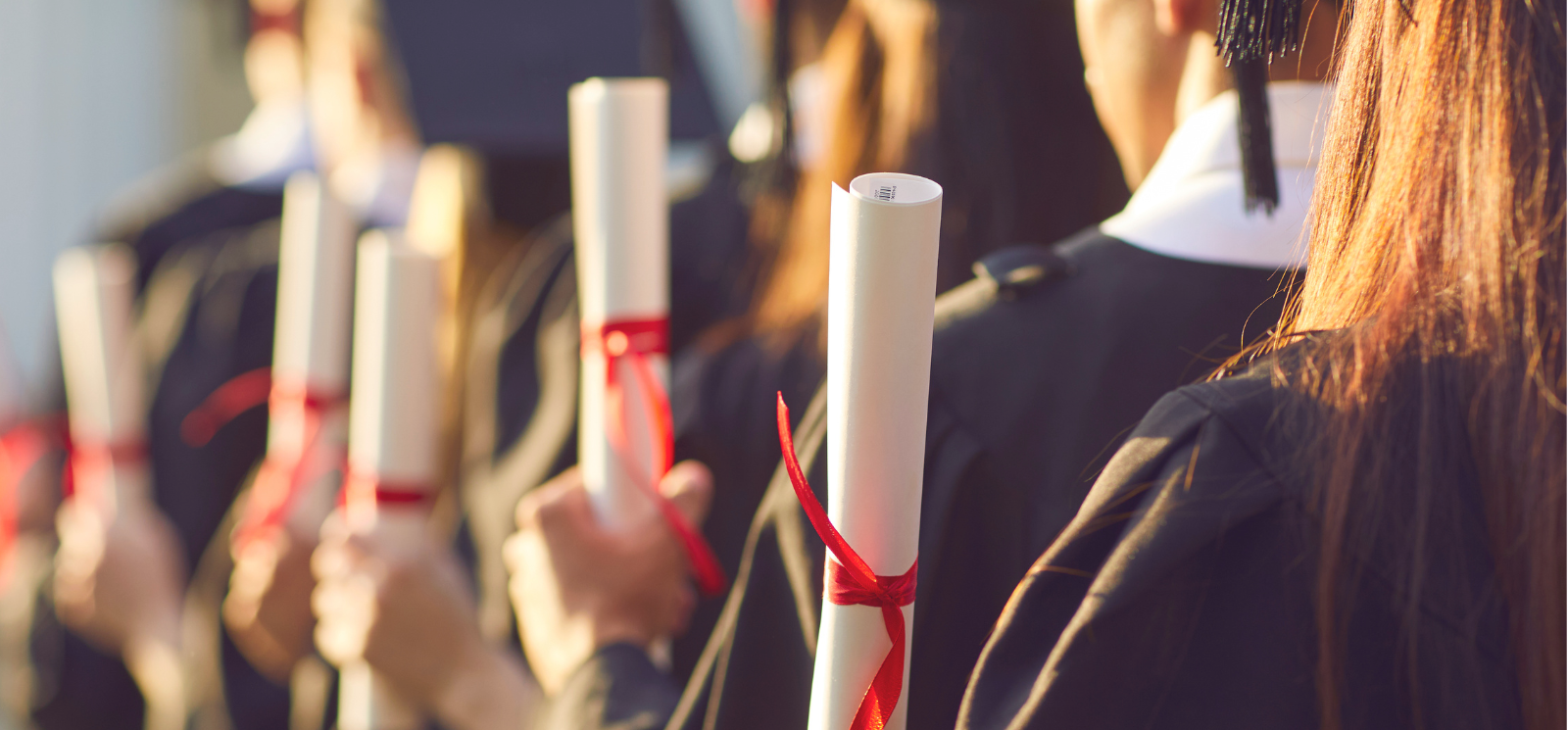 Line of graduates holding diplomas