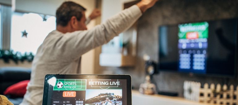 Man cheers at tv during a sporting event